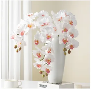 Detailed view of white artificial phalaenopsis orchid in a ceramic vase for home decor.