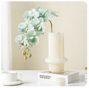 Artificial orchid flower branch home decor fake floral arrangement for interior photography