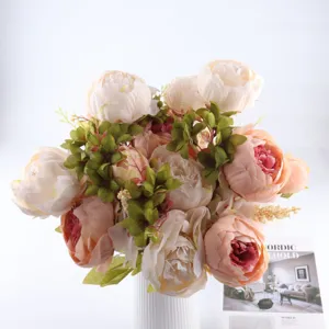 Gros plan détaillé d'un bouquet de pivoines artificielles, pétales et feuilles réalistes.