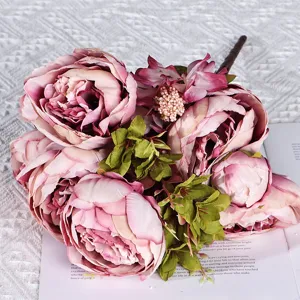 Gros plan d'un bouquet de pivoines roses artificielles avec feuilles vertes pour déco.