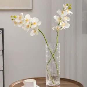 Orchidee Phalaenopsis artificiali in vaso di vetro, decorazione floreale realistica.