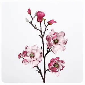 Close-up detail of artificial magnolia flower branch with realistic pink blooms and stems.