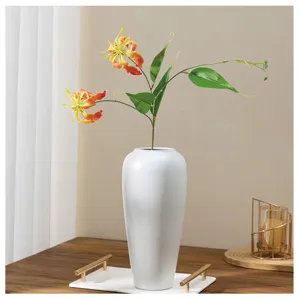 Vue de détail fleur de lys Gloriosa artificielle, arrangement floral déco maison en vase céramique.