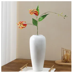 Fleur de lys gloriosa artificielle en vase céramique blanche détail déco maison.