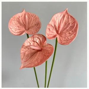 Detailed close-up of artificial PU anthurium flower, realistic pink petals and green stems.