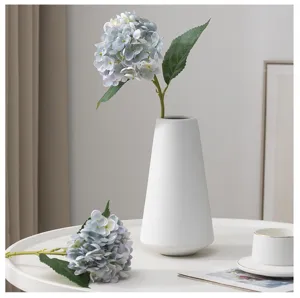 Vista dettagliata del mazzo di ortensie artificiali in vaso di ceramica bianca.