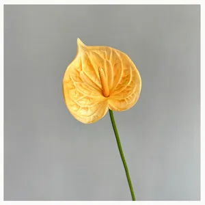Close-up detail of realistic bright yellow PU artificial anthurium flower stem for decor.