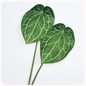 Artificial anthurium leaves close-up detail view, realistic faux green plant decor prop.