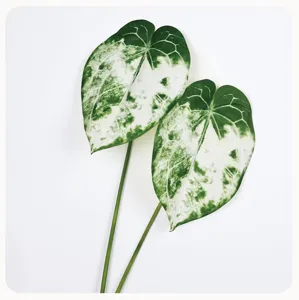 Artificial anthurium leaf detail view, realistic green and white variegated plant prop.