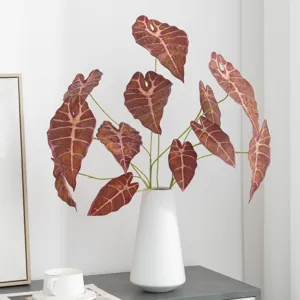 Artificial Alocasia leaf plant in white ceramic vase home decor floral arrangement display.