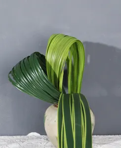 Artificial steel grass sword leaf detail shot, green floral arrangement accessory.