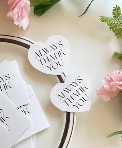Nahaufnahme von herzförmigen Geschenketiketten mit eleganter und minimalistischer Typografie.
