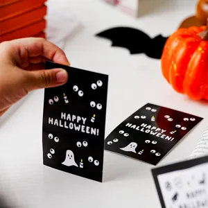 Halloween greeting card detail showing black design with cute ghost eyes and holiday text.