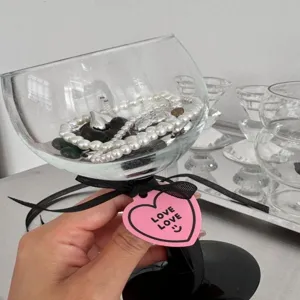 Close-up van roze hartvormig cadeaulabel met liefdestekst voor romantische decoratie.