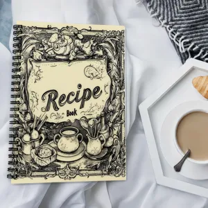Vintage style recipe book detail, spiral bound notebook with hand-drawn dessert illustrations on cover.