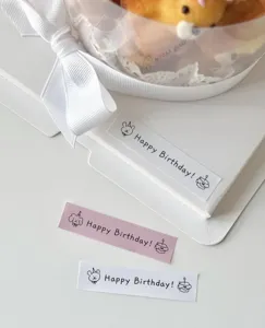 Vista ravvicinata dell'adesivo regalo di compleanno minimalista e scatola con fiocco.