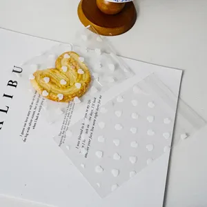Clear self-adhesive plastic bags with white heart patterns, detail view showing packaging use.