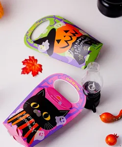 Close up detail view of colorful Halloween paper candy boxes featuring cute cat and pumpkin graphics.