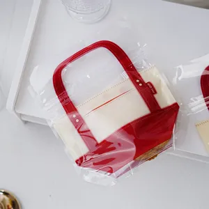 Transparent plastic cookie packaging bag with red handle for gift and food storage use.