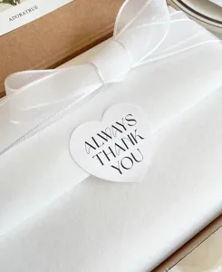 Nahaufnahme Detail eines weißen herzförmigen Geschenkverschlussaufklebers mit Text.