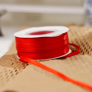 Red double-faced polyester ribbon spool for gift wrapping and DIY crafting details.