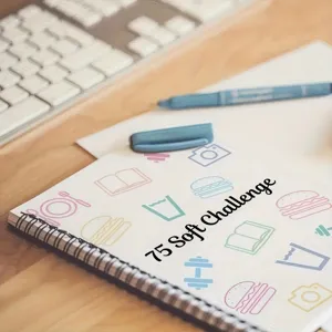 Close-up detail shot of the 75 soft challenge planner notebook on a wooden desk setup.