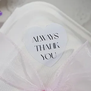 Nahaufnahme Detailansicht eines herzförmigen Geschenkeaufklebers mit edlem Text und Schleife.