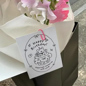 Close-up detail of a minimalist black and white birthday greeting card with flowers.