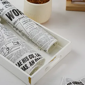 Papel de horno antiadherente con diseño de periódico vintage en bandeja blanca para alimentos.