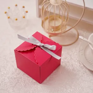 Pink paper gift box detail view, elegant scalloped flap and silver ribbon for wedding party.