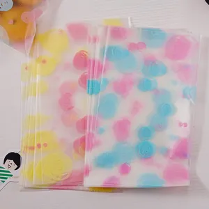 Sacs d'emballage en plastique givré avec motifs de cercles colorés pour biscuits et noix.