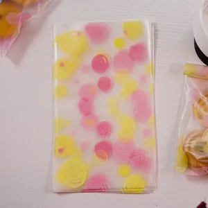 Sachet d'emballage en plastique givré avec des cercles roses et jaunes pour biscuits.