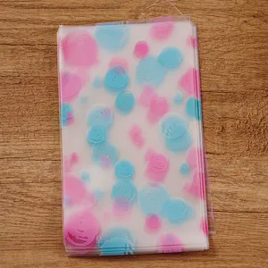 Sachets d'emballage en plastique givré avec cercles roses et bleus pour biscuits et pains.
