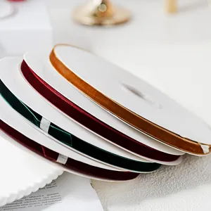 Velvet ribbon detail shot showing stacked colorful spools for gift wrapping and holiday crafts.