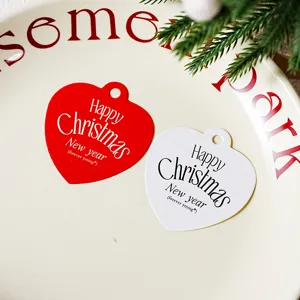 Close up detail of red and white heart shaped Christmas paper tags for gift wrapping and holiday decor.