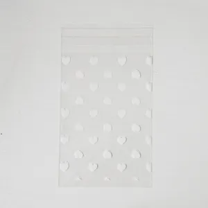 Clear plastic self-adhesive bag featuring minimalist white heart patterns for romantic gift packaging.