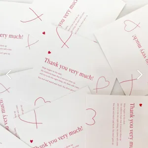 Detalle de tarjetas de felicitación cuadradas con corazón rojo y texto de agradecimiento.