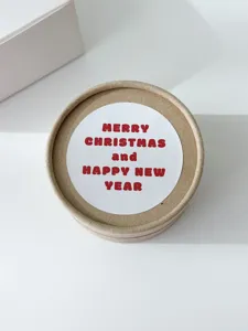Detailed close-up of a round kraft paper gift box featuring a festive Christmas sticker.