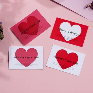 Close-up detail shot of romantic love heart greeting cards with English text on pink background.