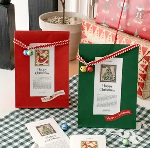 Bolsas de papel planas rojas y verdes de Navidad con etiquetas festivas para regalos.