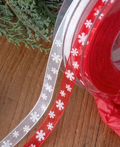Dettaglio in primo piano di nastri in chiffon con fiocchi di neve natalizi per decori.