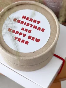 Christmas round decorative sticker, festive holiday greeting label for gift packaging detail.