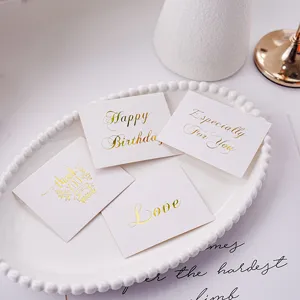 Detail view of minimalist gold-stamped greeting cards with elegant foil text for gifts.