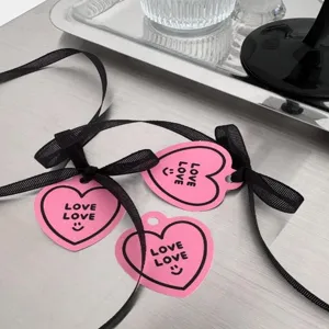 Detailopname van schattige roze hartcadeaulabels met zwarte linten voor feestdagen.