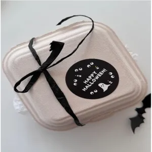 Eco-friendly pulp bento box with black ribbon and Halloween sticker for festive gift packaging.