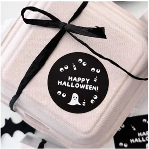 Close-up detail of Halloween gift box packaging with black ribbon bow and spooky sticker.