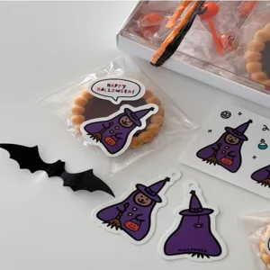 Halloween decorative stickers and gift tags close up featuring cute witch patterns for packaging.