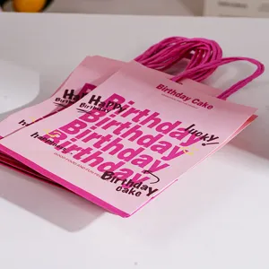 Pink paper gift bags with birthday print and twisted handles for party favors and presents.