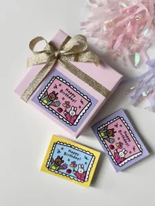 Detailed view of birthday greeting cards and gift box set with cute stamp design and ribbon.