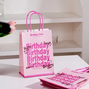 Pink happy birthday paper gift bag with handles for party favors and sweet celebrations.